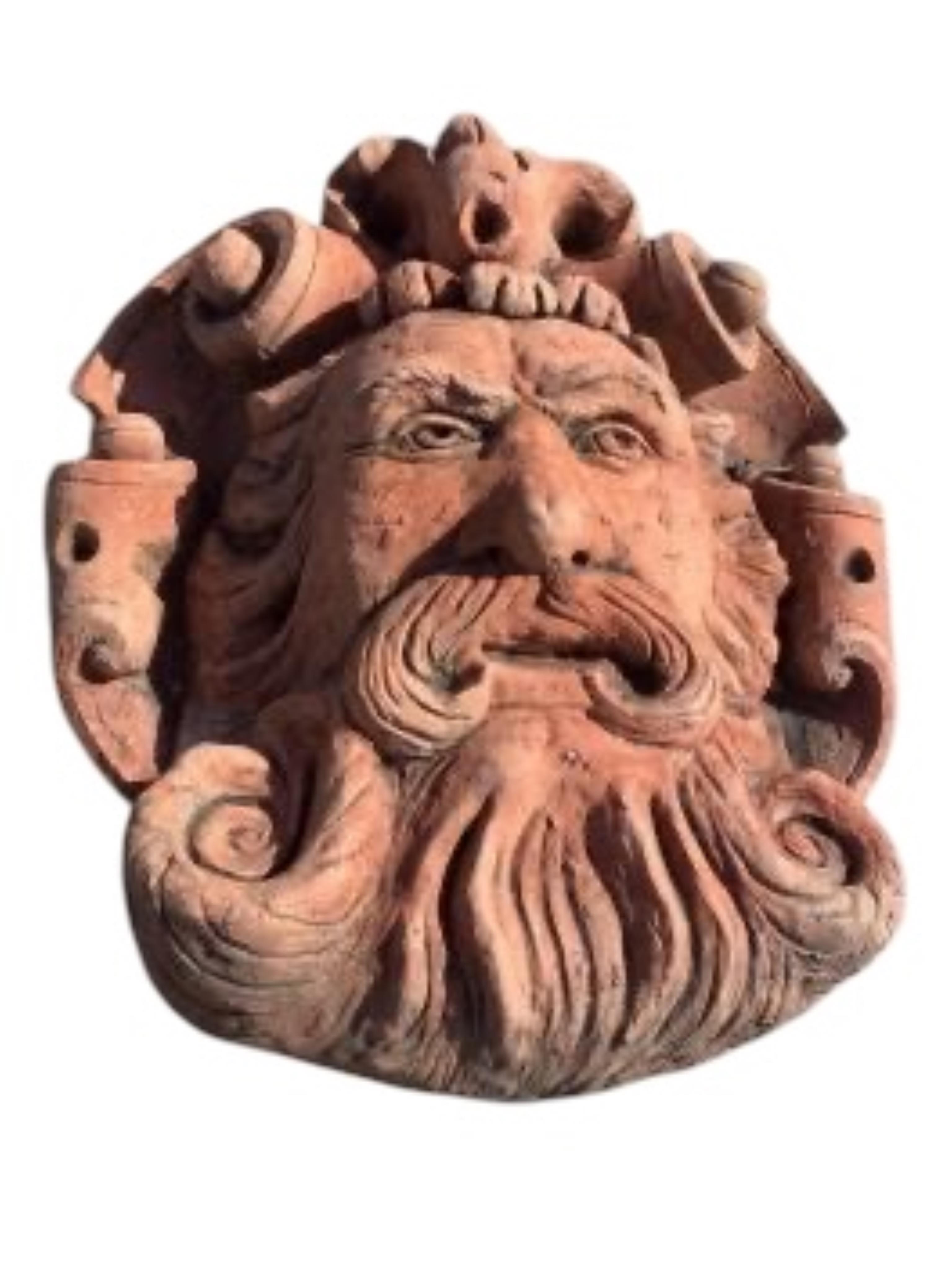 Three cast stone and terracotta garden wall mask appliqués, largest height 42cm